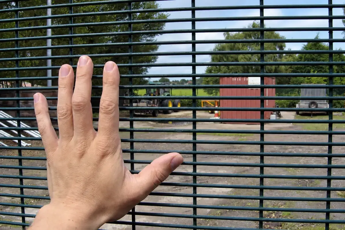 Hand beside close spaced welded security mesh