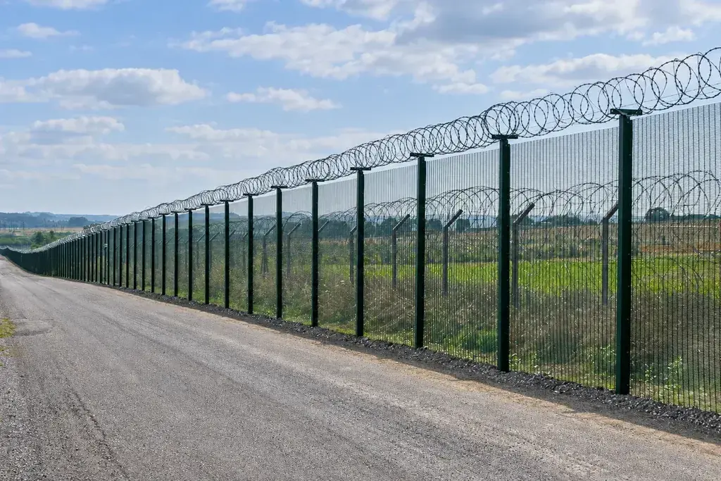Close spaced 358 security mesh fence beside a perimeter road