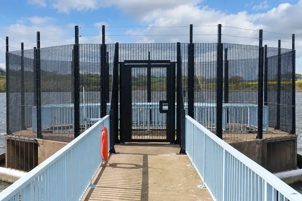 Security mesh pedestrian gate between fixed fence panels