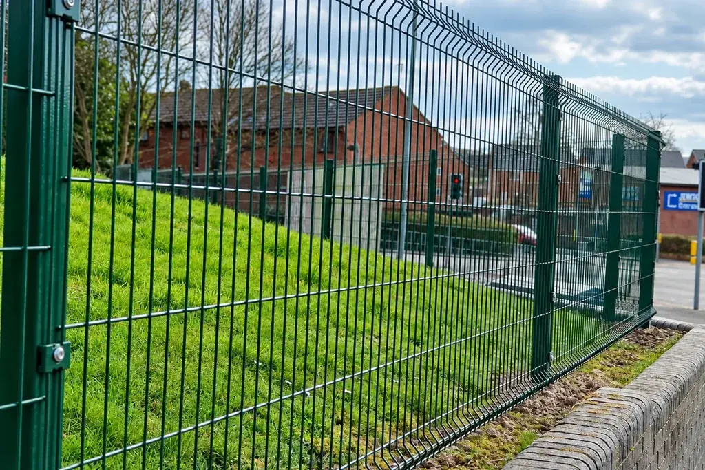 Profiled welded mesh fence along an open site boundary