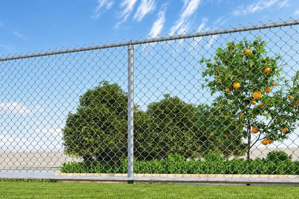 Green chain link fence along a landscaped boundary