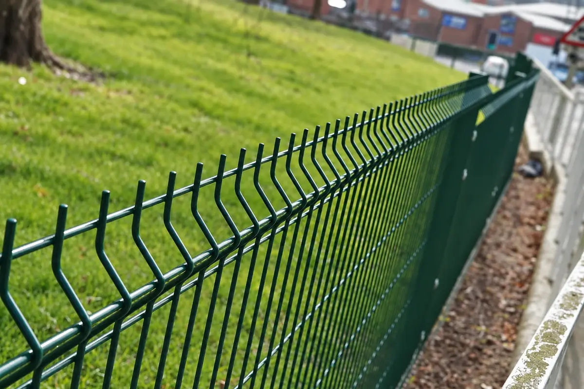 Green profiled mesh fence with repeated bends along its face