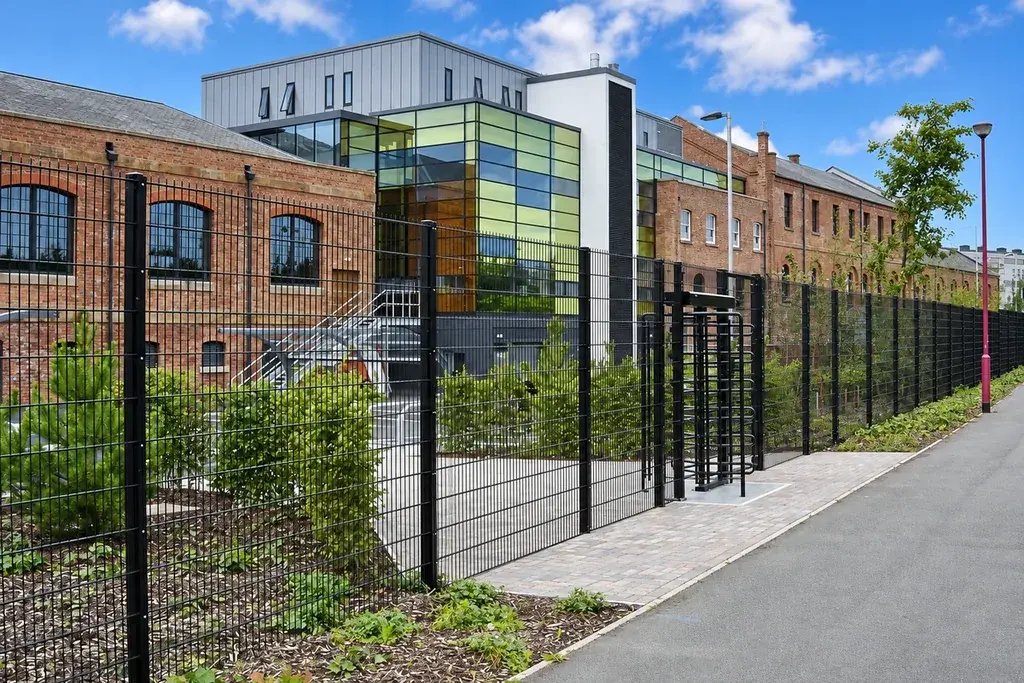 Mesh fence with repeated bays along a commercial boundary
