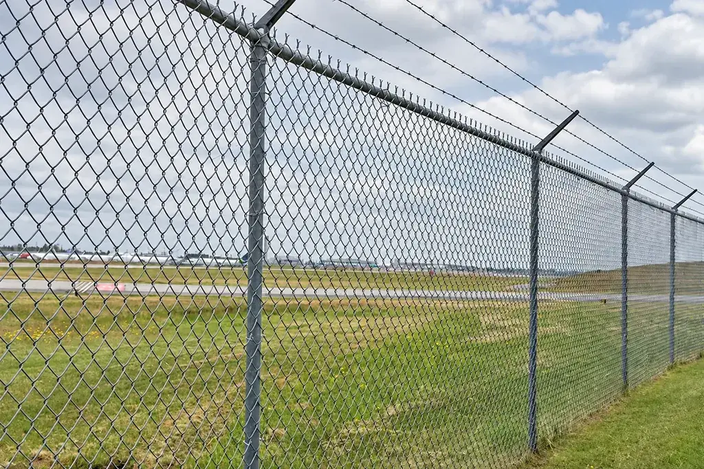Long installed chain link fence with repeated posts and top supports