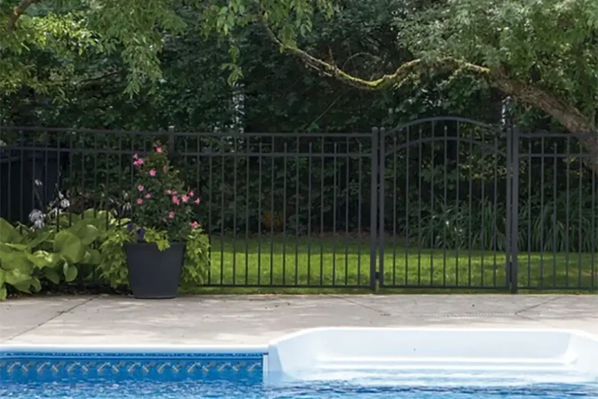 Black aluminium fence installed beside an outdoor swimming pool