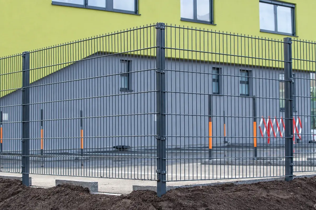 Welded mesh fence panels with a rectangular grid around a building
