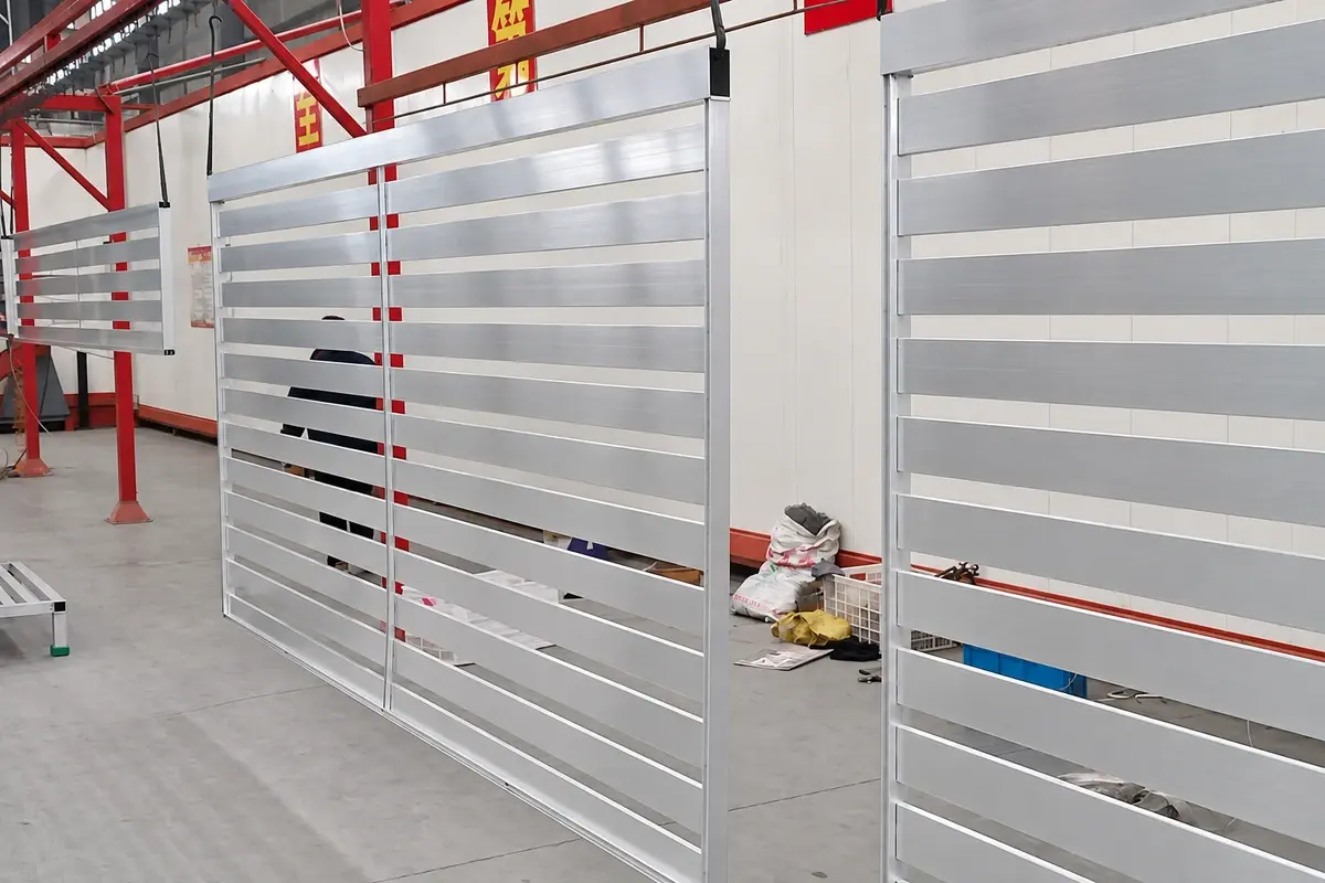 Light aluminium slat fence panels with horizontal gaps in a workshop