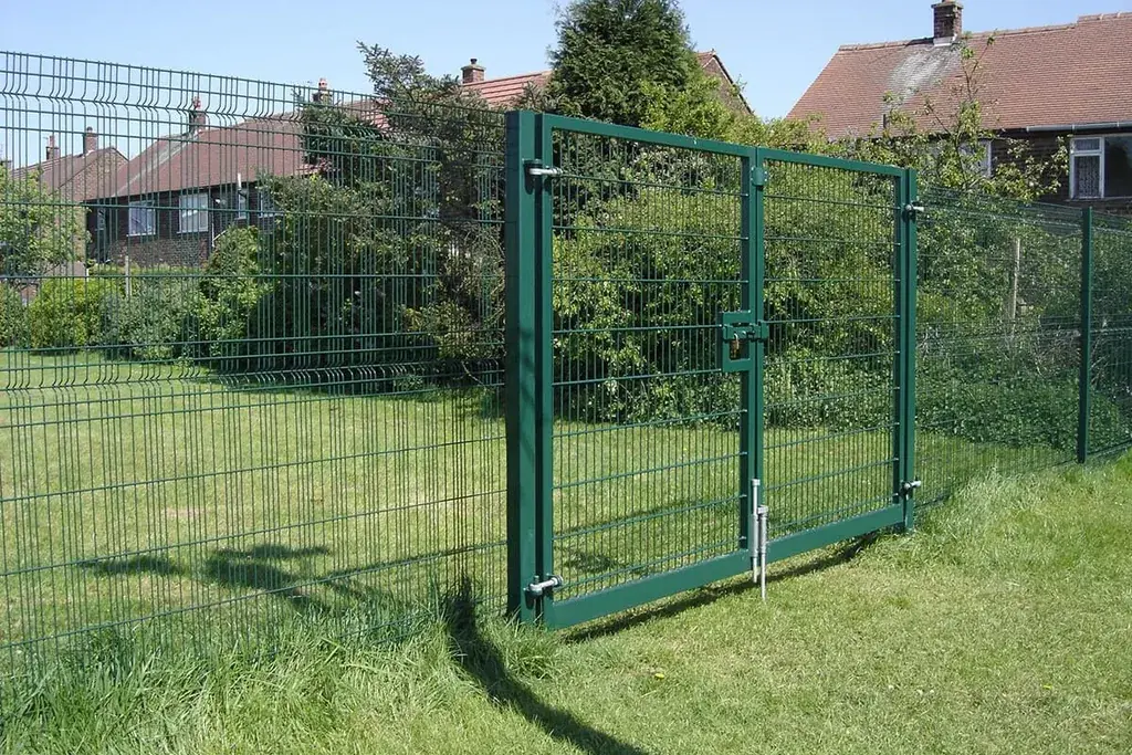 Green welded mesh pedestrian gate within an open fence line