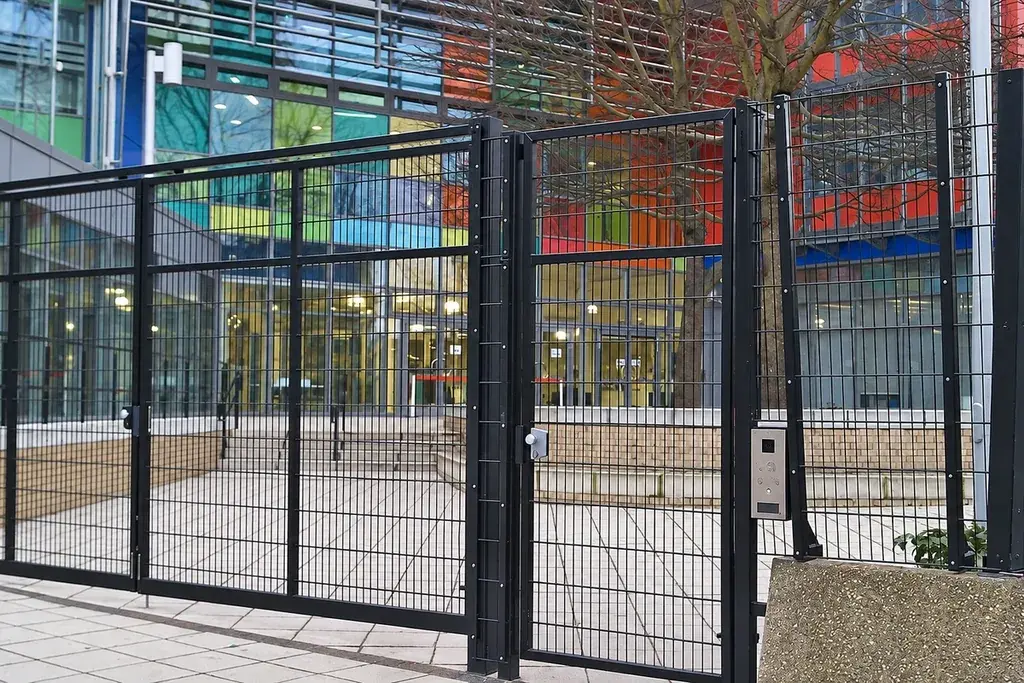 Mesh vehicle gate and adjoining pedestrian access gate at a site boundary