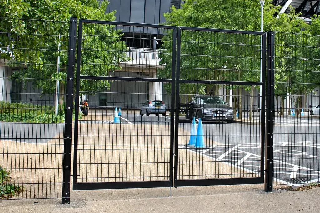 Black double-leaf mesh gate installed between two gate posts