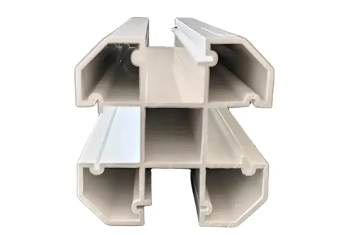 Cut end of a white formed fence post showing internal channels and walls
