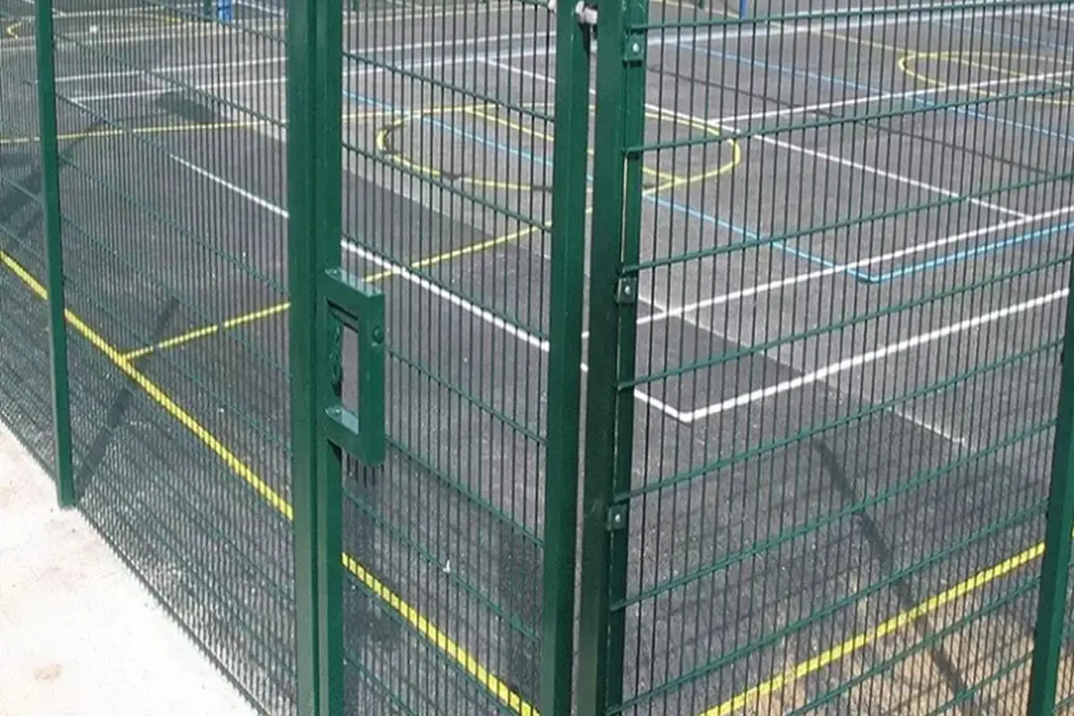 Green square post joining two welded mesh fence panels at a corner