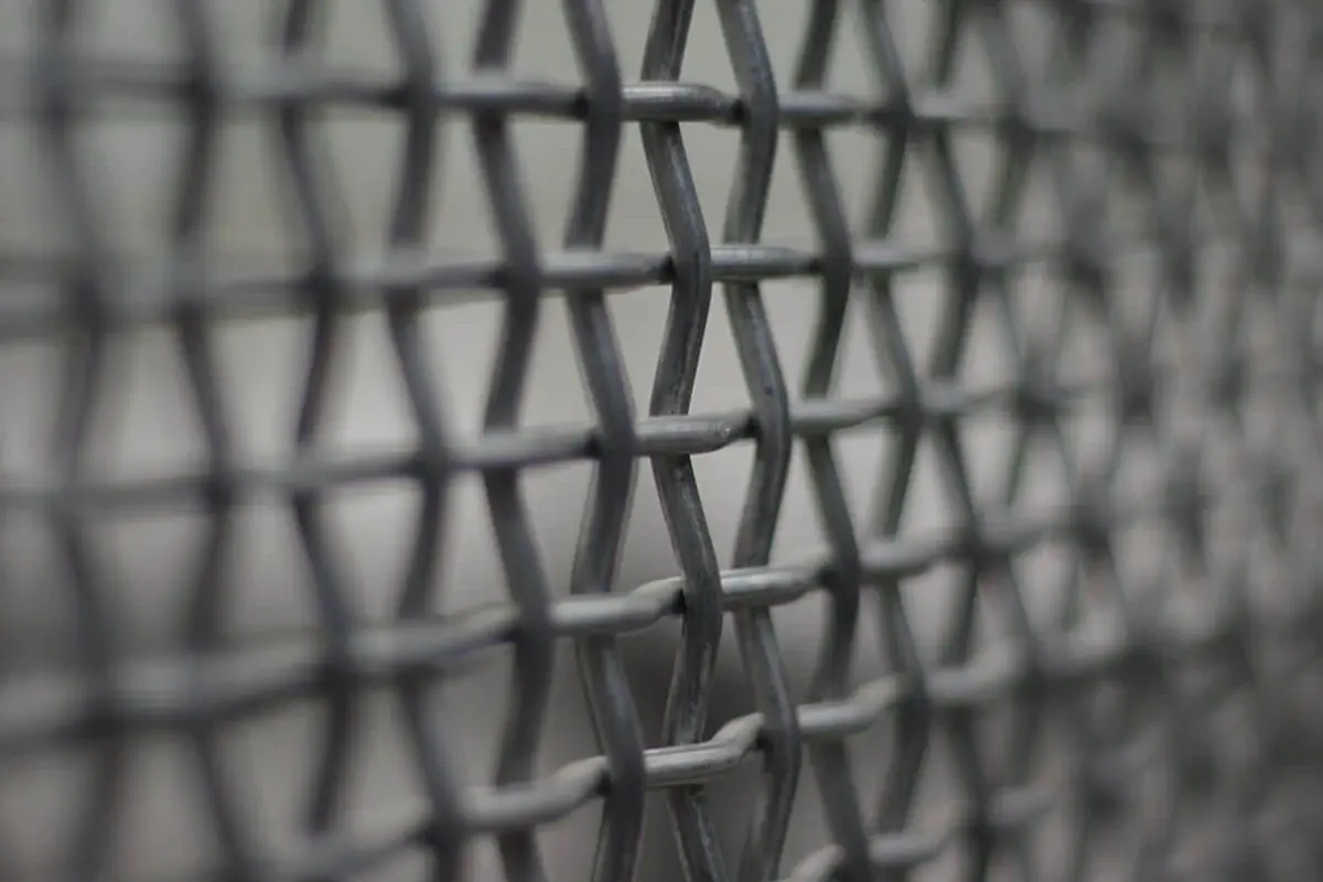 Close view of overlapping small aperture mesh wires at a fence panel edge