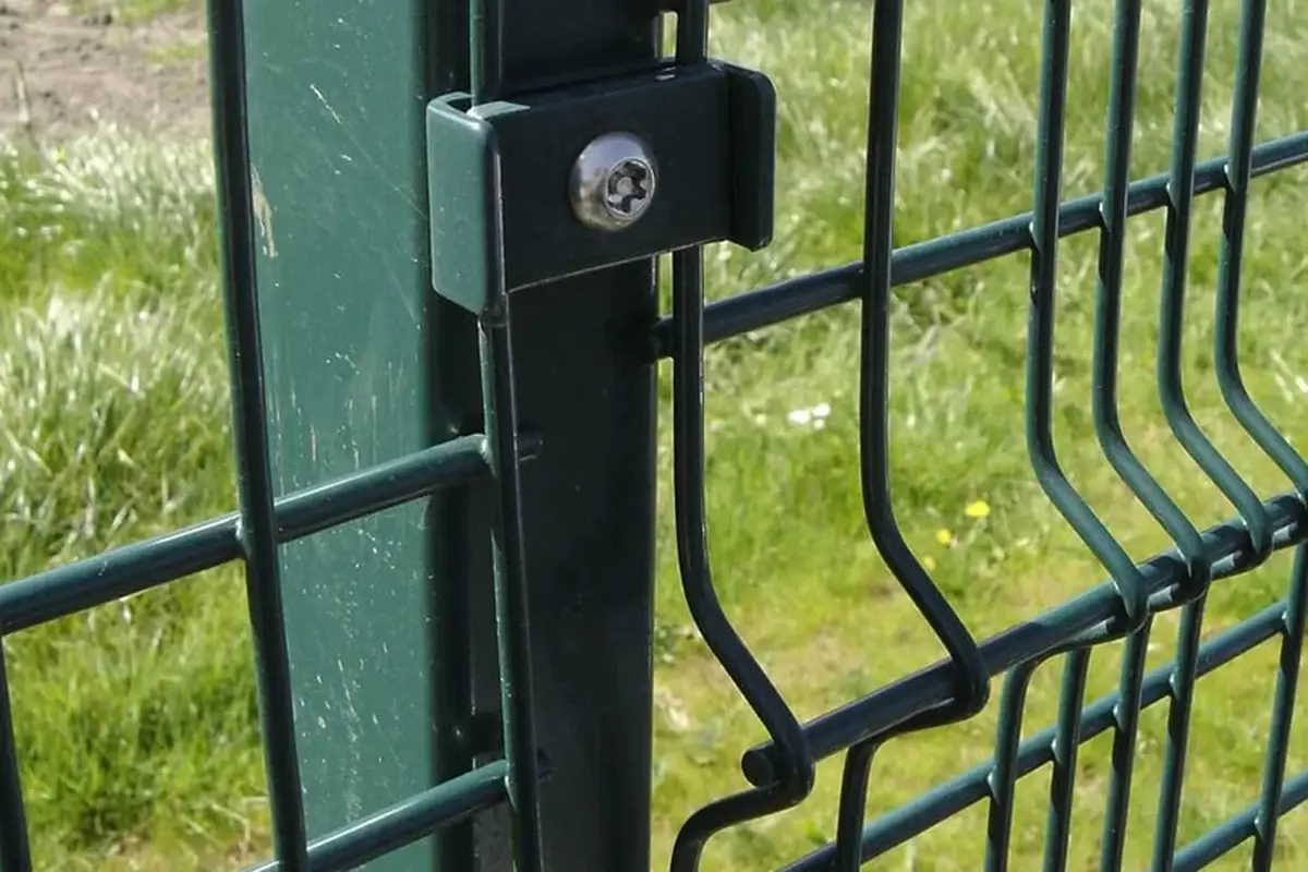 Close view of a bolt holding a green mesh fence fitting to a post