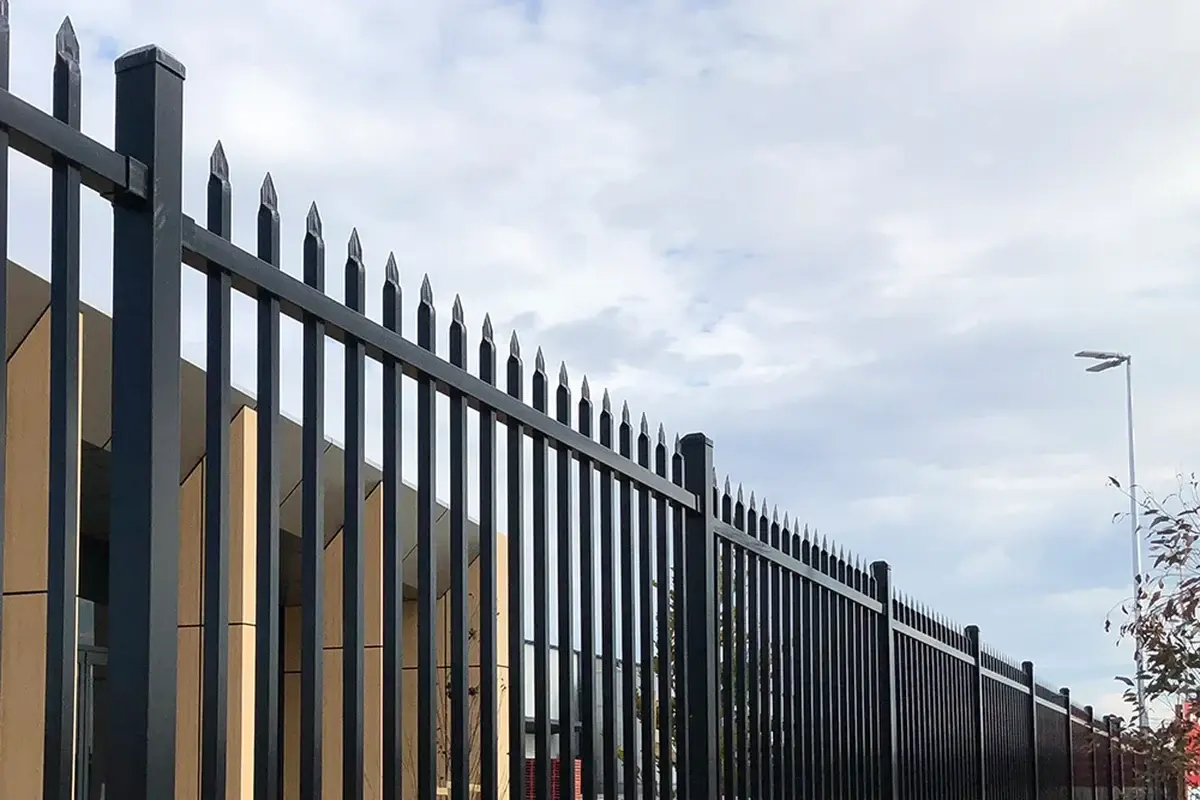 Black metal fence line with caps visible on repeated posts