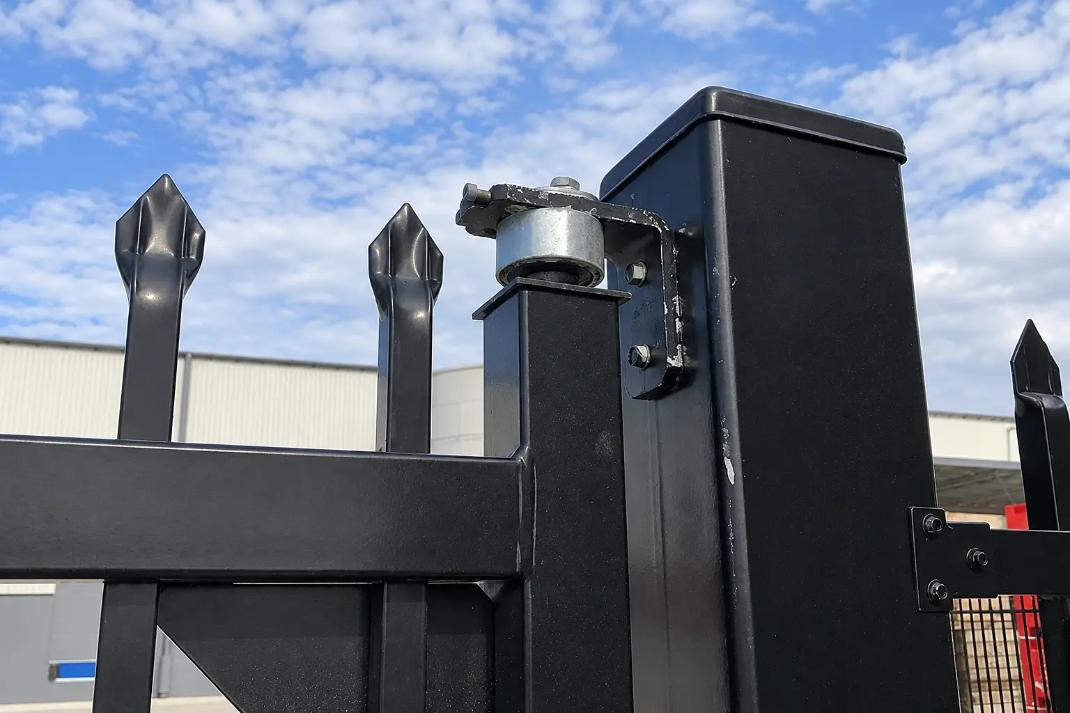 Close view of a bolted metal fence bracket where rails meet a post