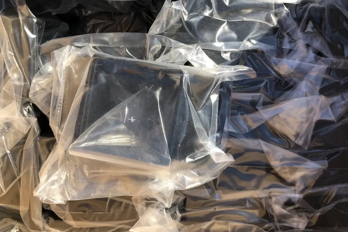 Black fence accessory components grouped inside clear plastic bags