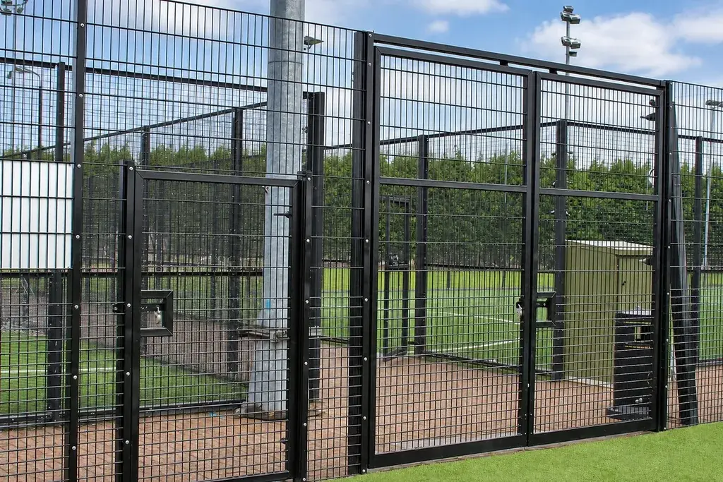 Metal gate in a mesh sports enclosure