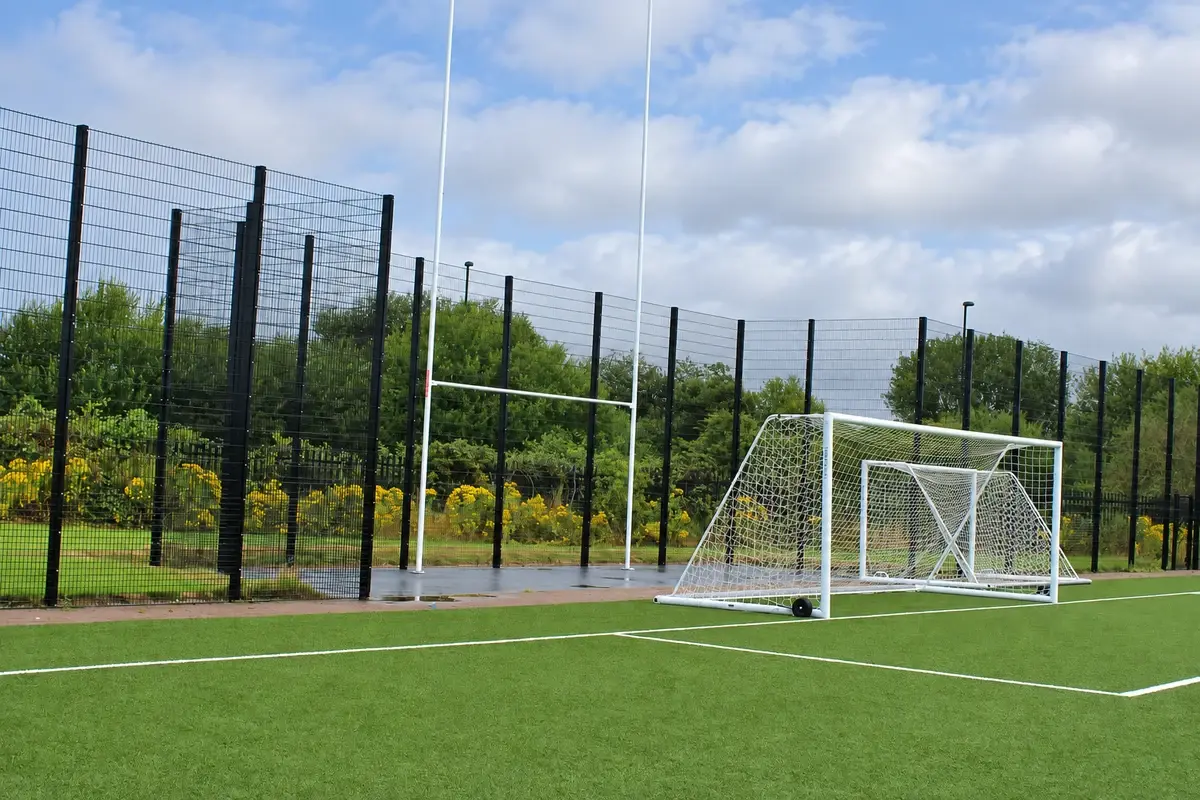 Tall mesh sports boundary behind a football goal