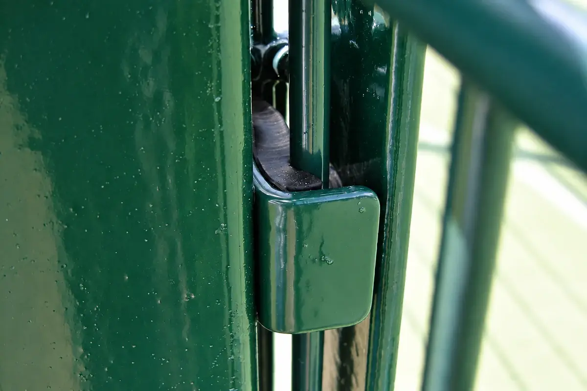 Close view of a green metal tennis fence joint