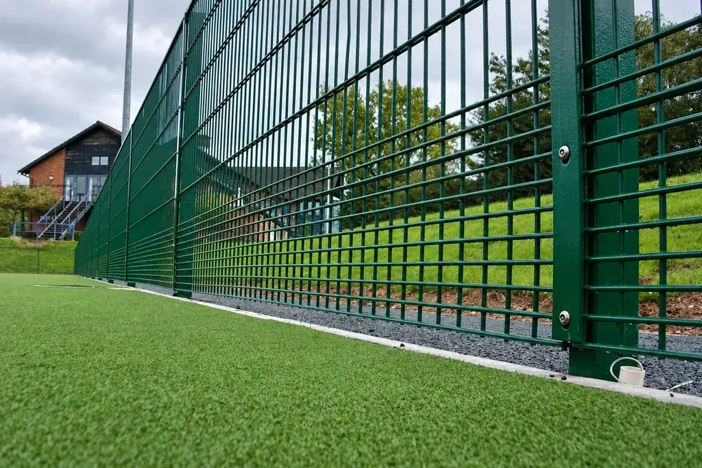 Close view of green sports mesh fencing beside a hockey pitch