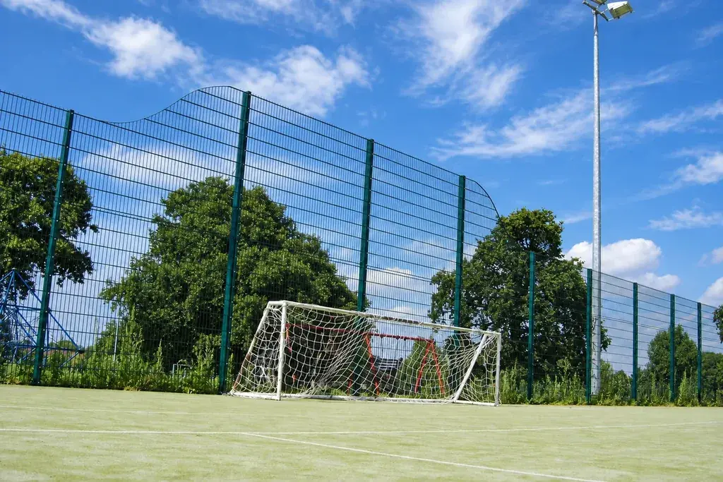 Tall sports mesh fencing behind a playing field goal