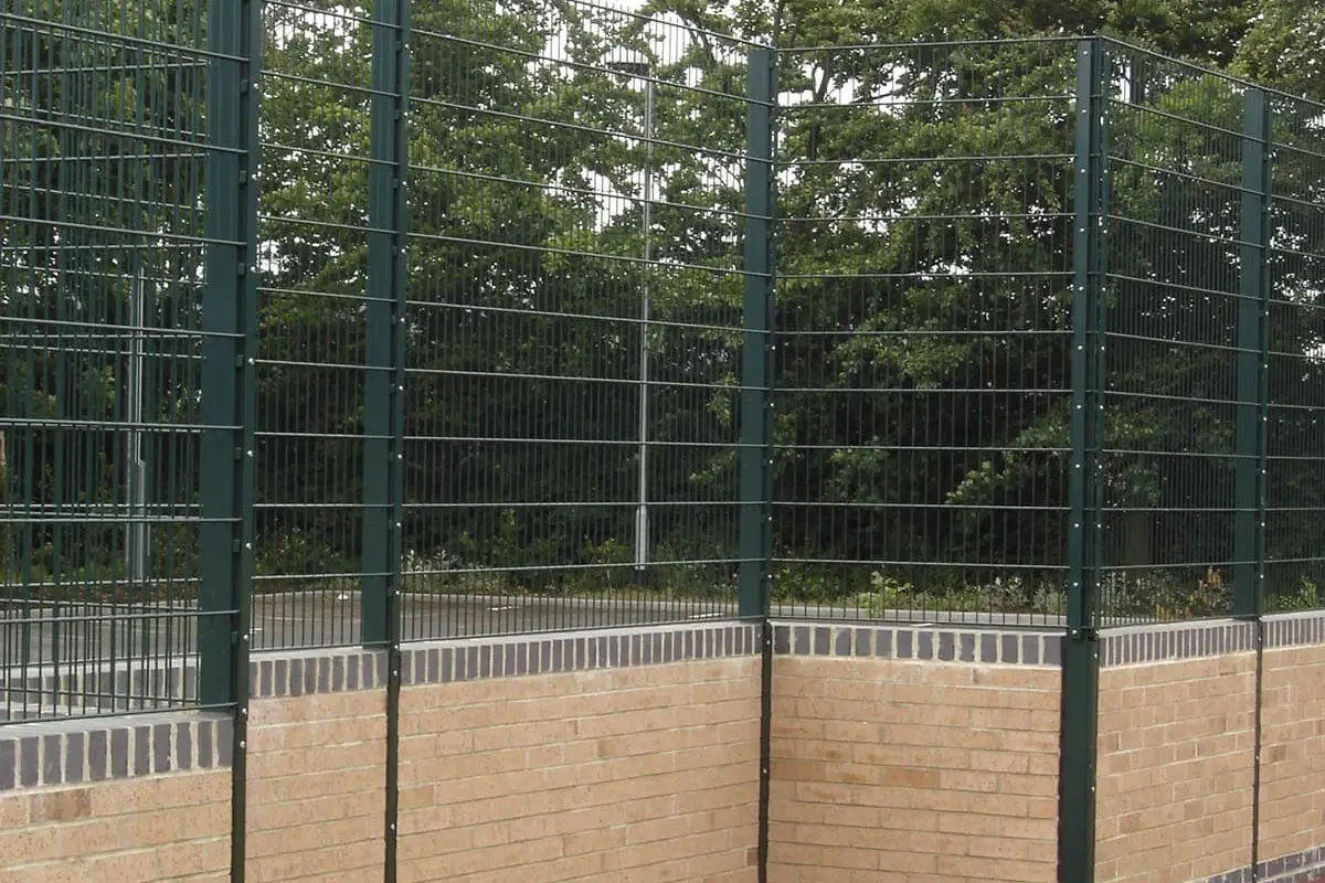 Tall green metal sports mesh enclosing an outdoor playing area