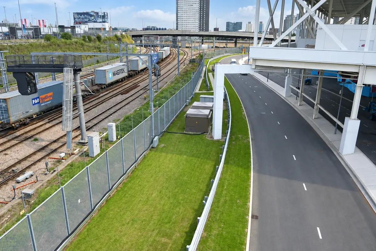 Metal mesh boundary fence running beside railway tracks