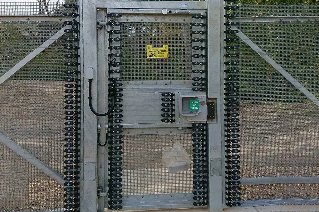 Metal mesh pedestrian gate with access hardware in a matching fence