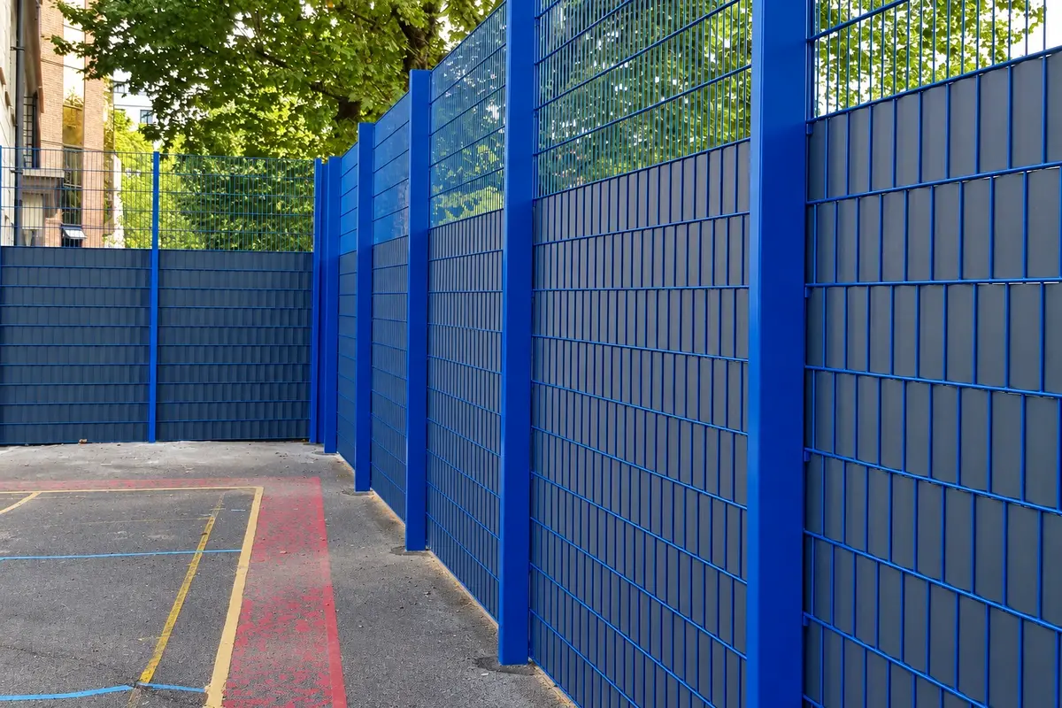 Blue metal mesh fence panels fitted with partial visual screening