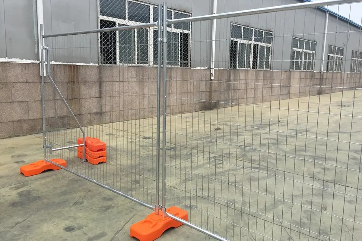 Temporary mesh fence panels supported by orange ground feet