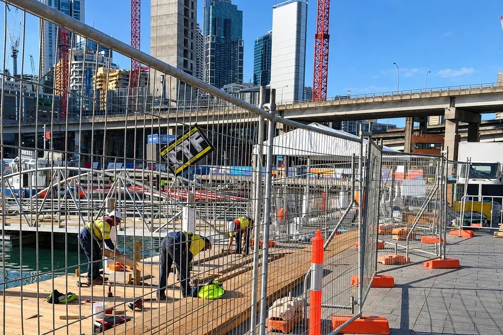 Temporary mesh panels defining a construction site beside a public pavement