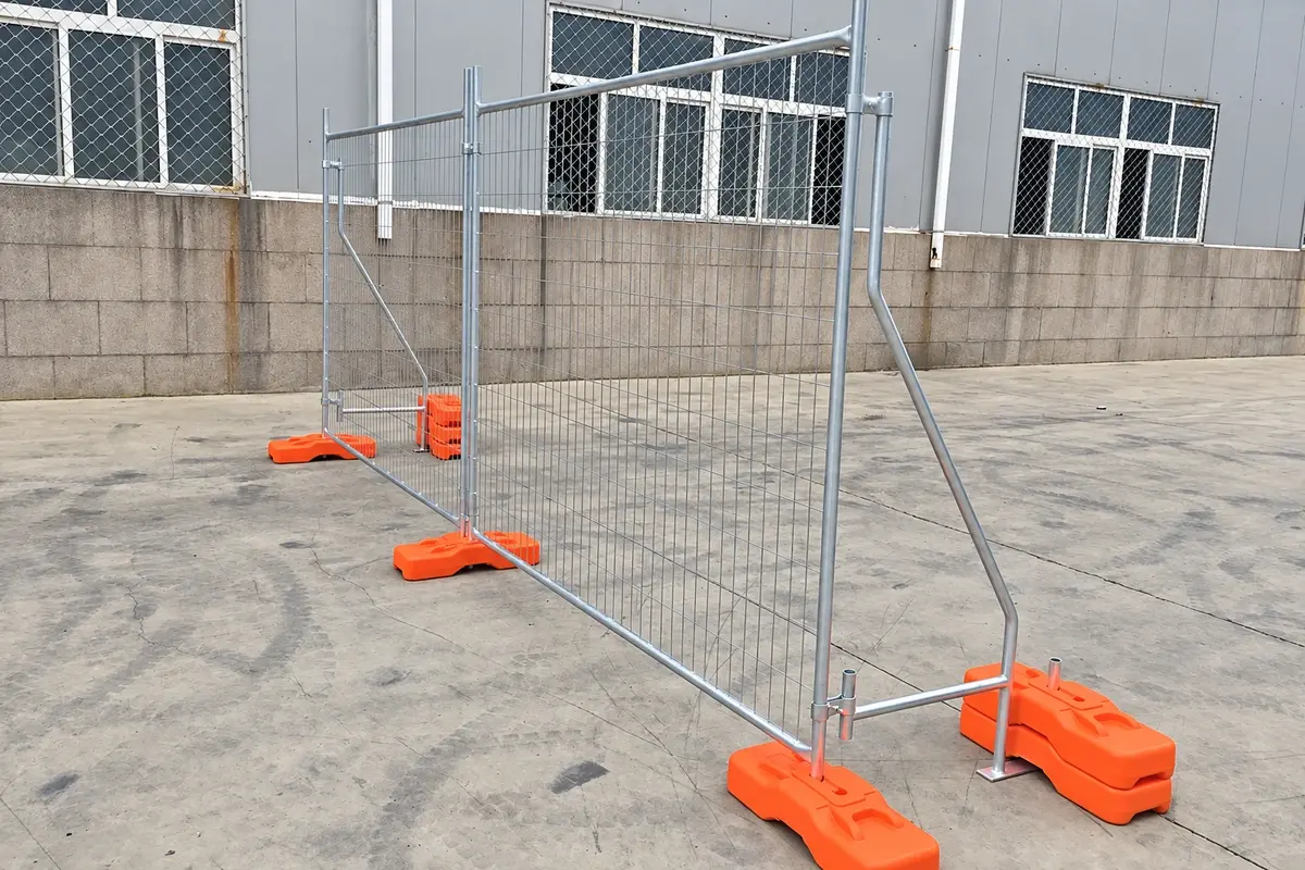 Temporary welded mesh fence run with surface supports beside a work area