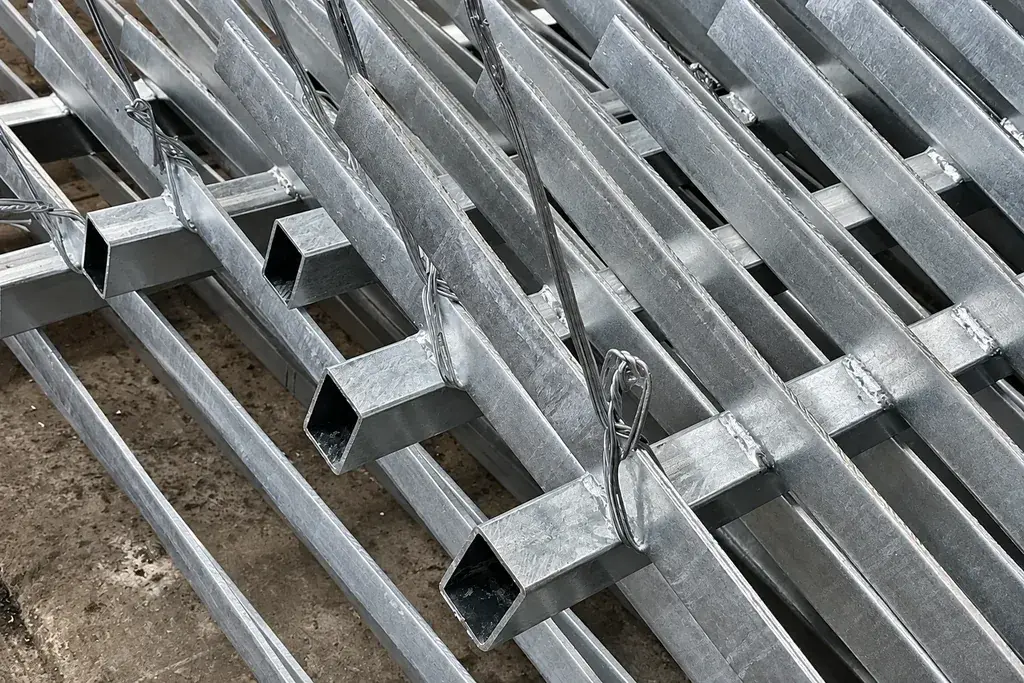 Close view of galvanized fabricated steel fence sections stacked together