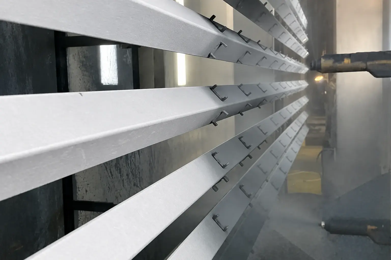 Fence posts passing through a powder coating booth