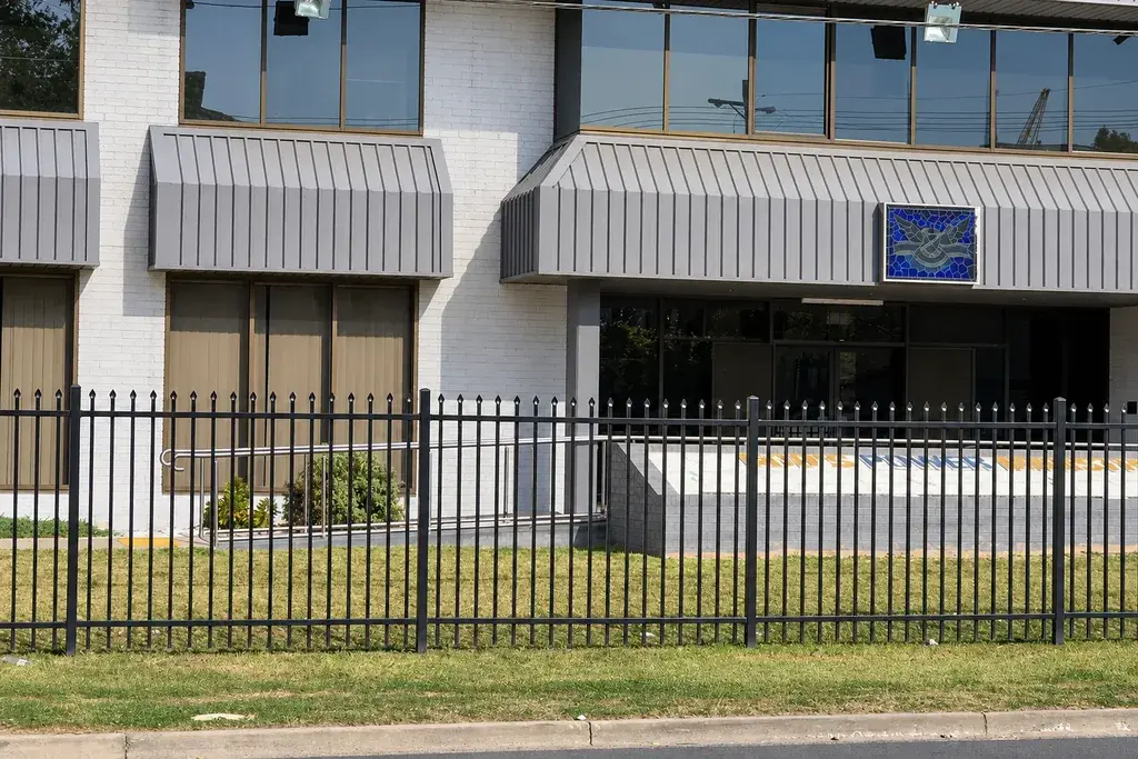 Black coated steel fence installed outside a commercial building