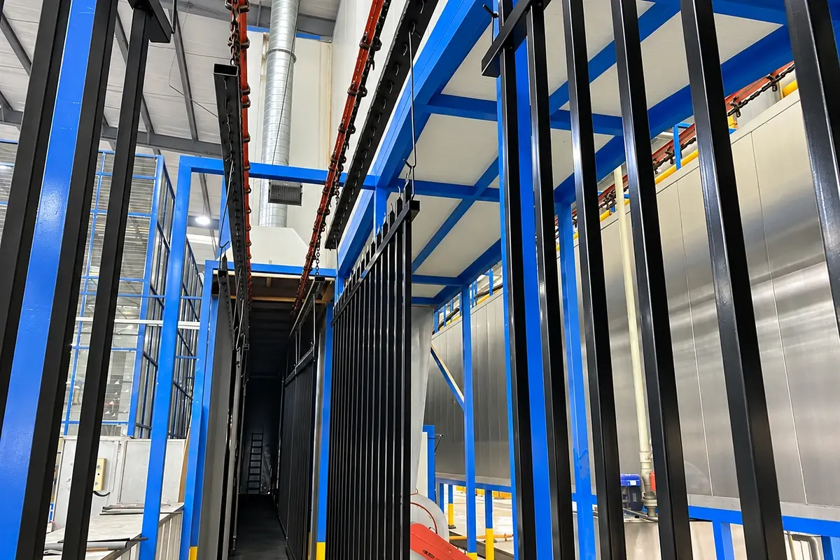 Steel fence components suspended on an industrial coating line