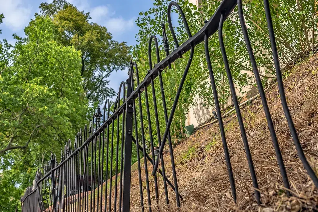 Bent metal security fence along an outdoor boundary