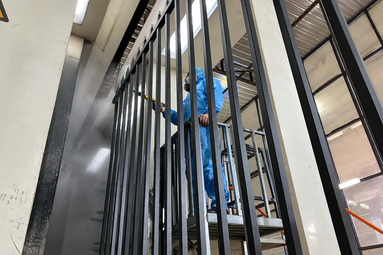 Metal fence panels suspended on a production coating line
