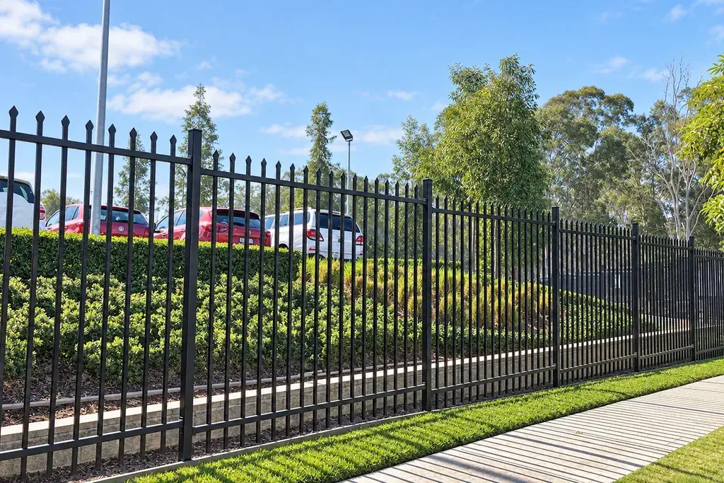 Black coated metal fence installed along a path