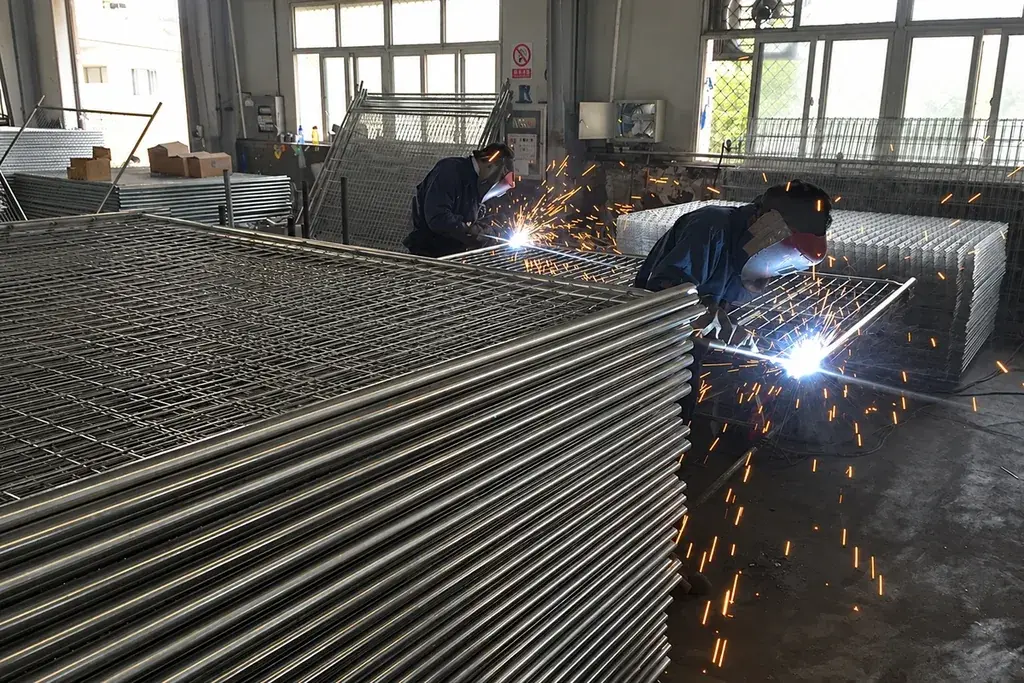 Welded mesh panels passing through a welding line in a workshop