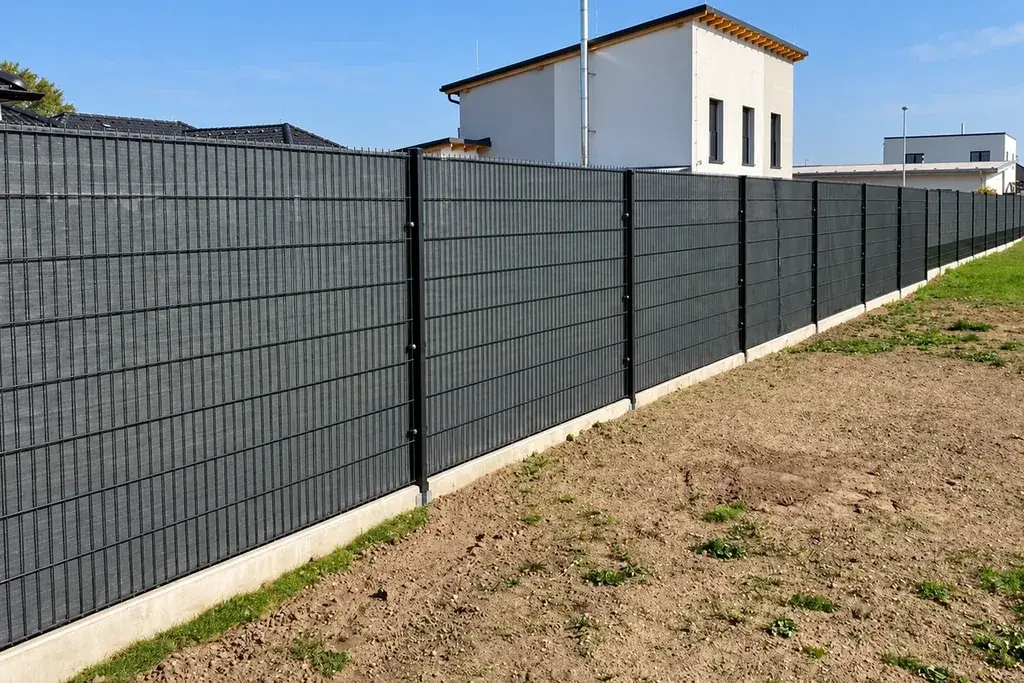 Long run of flat welded mesh fence panels beside a residential site