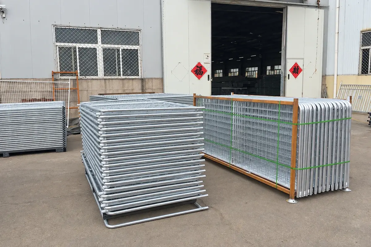 Stacks of metal mesh farm gates secured for transport outside a workshop