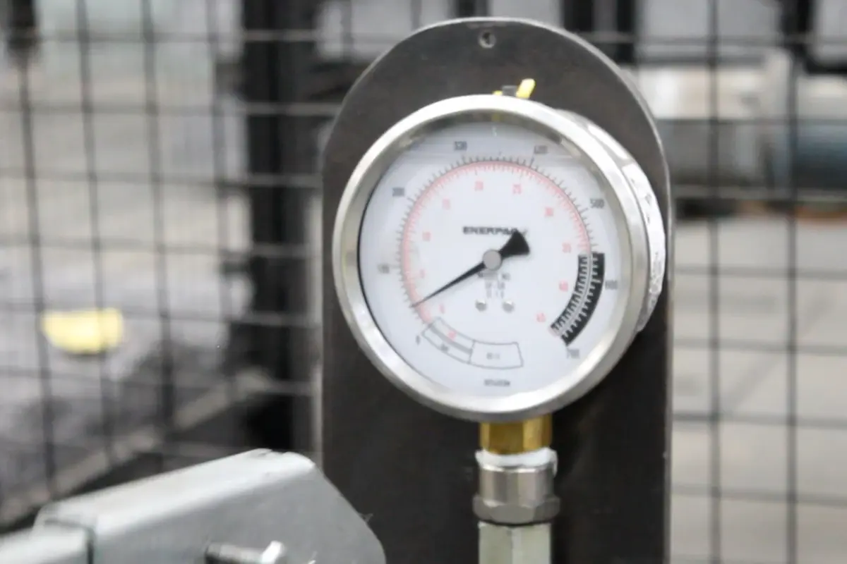 Analogue gauge beside a welded mesh test setup