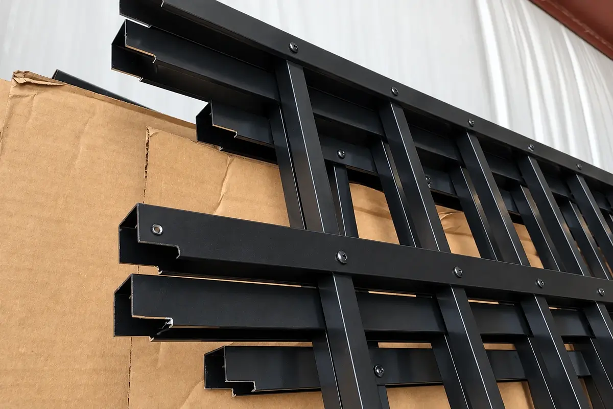 Black fence panel assemblies stacked during production