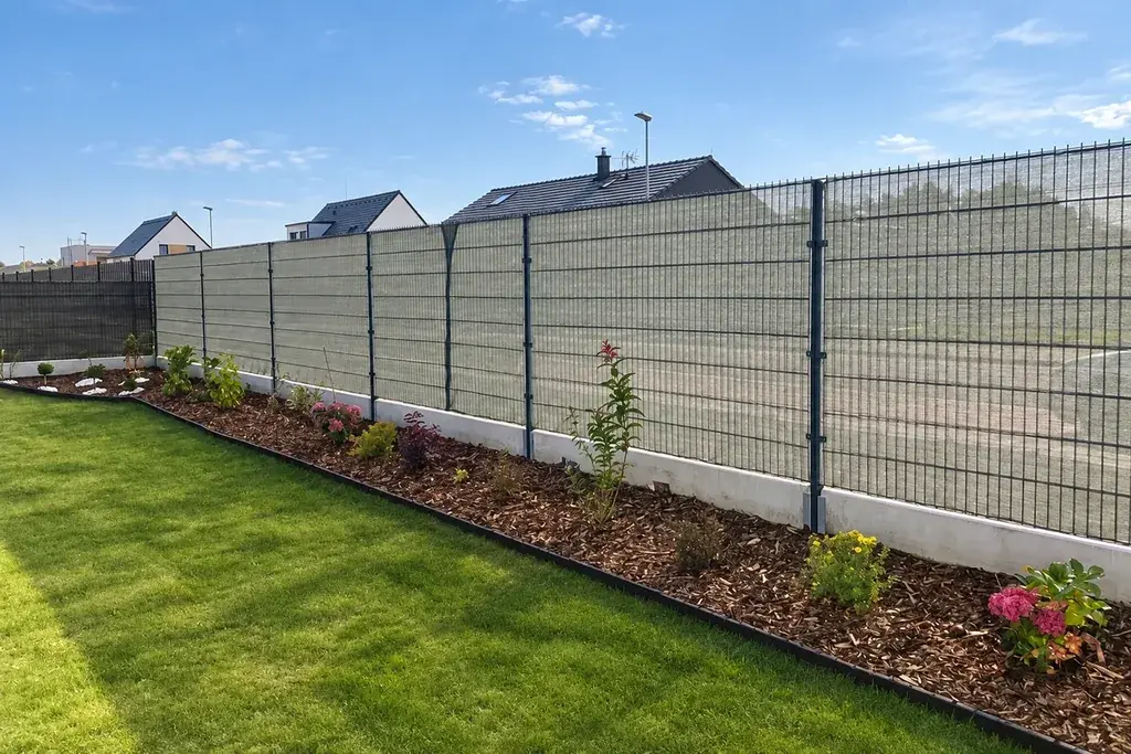 Continuous installed welded mesh fence panels along a garden boundary