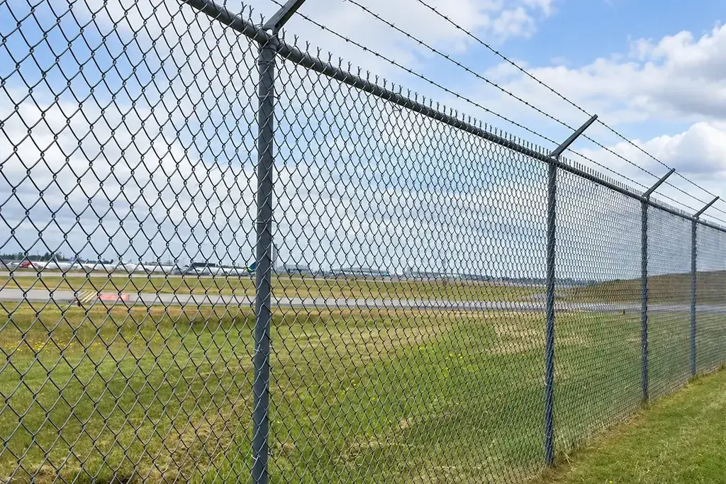 Installed chain-link fence with posts and angled top wires