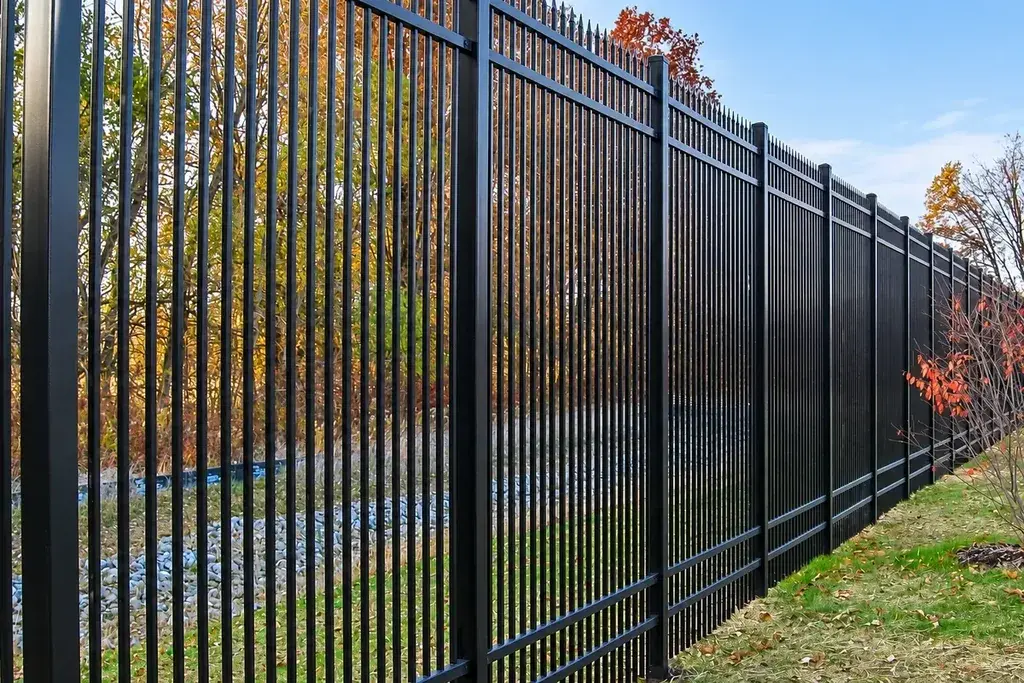 Long installed black steel fence run with repeated posts