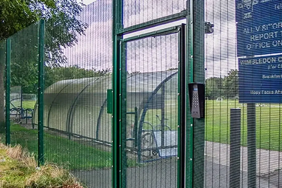 Green security mesh pedestrian gate within a fence line