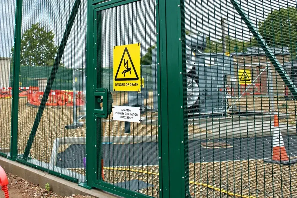 Green mesh pedestrian gate between fence posts